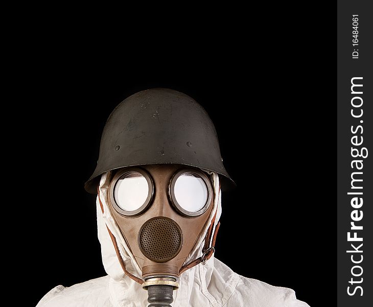 Person in gas mask and helmet on dark background