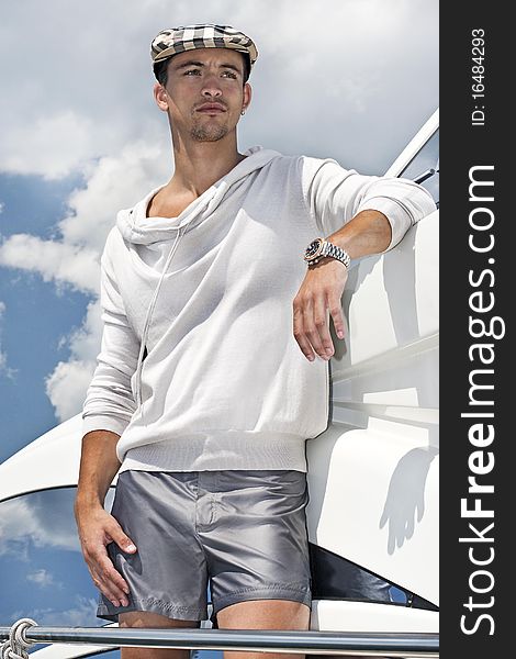 Young attractive man looking away on a yacht, with a cloudy background . Young attractive man looking away on a yacht, with a cloudy background .