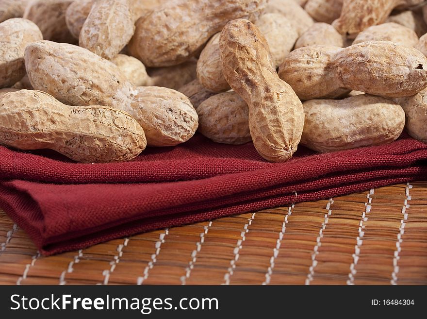 Nuts Peanuts on a mat with a red napkin.