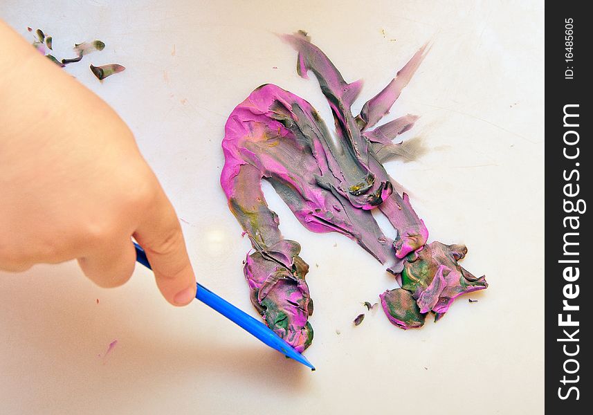 Little boy sculpts figure out of plasticine