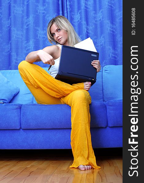 Thinking woman working with PC at home in sofa