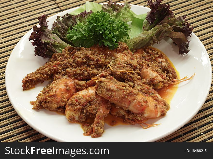 A dish of chili prawn served with garnishing and fermented durian sauce