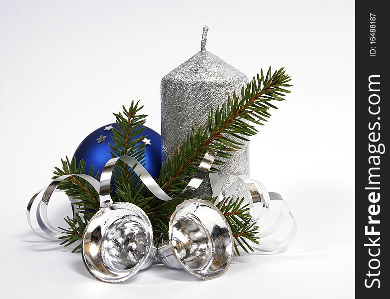 Silver candle with the twig of the spruce and bells. Silver candle with the twig of the spruce and bells
