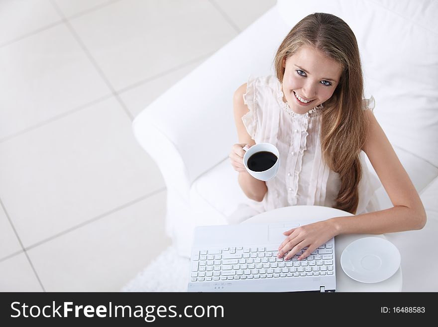 Attractive young girl with coffee and laptop. Attractive young girl with coffee and laptop