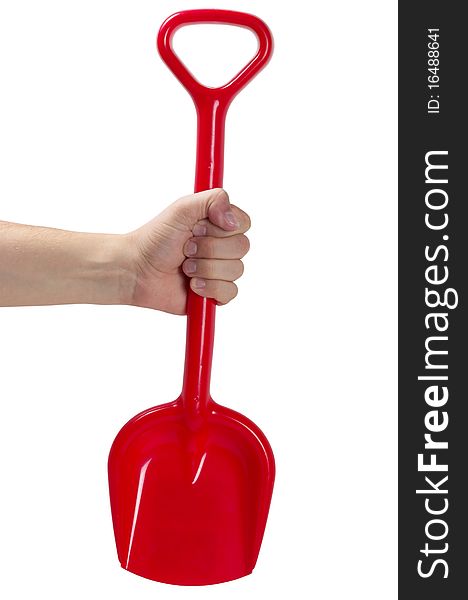 Red plastic toy spade in the hand isolated over white background. Red plastic toy spade in the hand isolated over white background