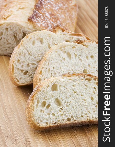 Fresh baked baguette bread laying on cutting board.