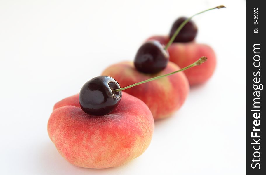Peaches and cherries on white background