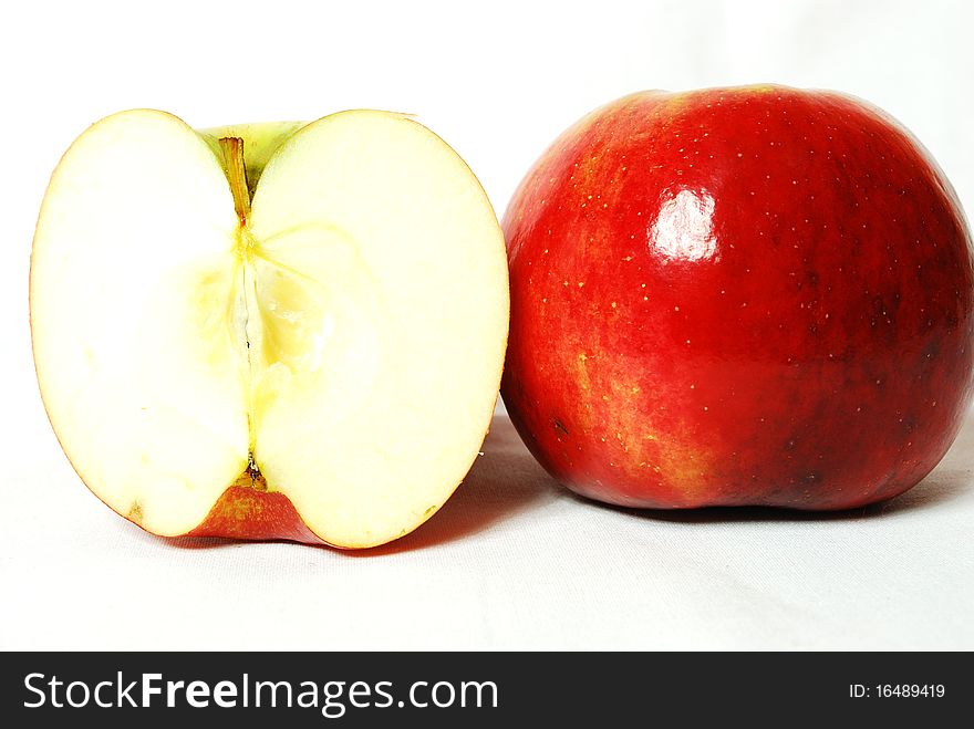Red apple, a whole and the second is the split in two, on white. Red apple, a whole and the second is the split in two, on white