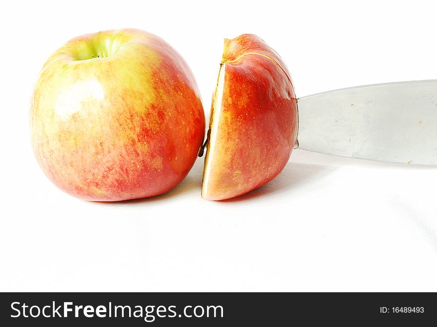 Apples, one of them is a whole second half and it cuts the knife still in half, white background