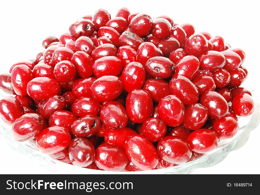 Dogwood berries on a plate on a white background, red berries, dishes, still life. Dogwood berries on a plate on a white background, red berries, dishes, still life