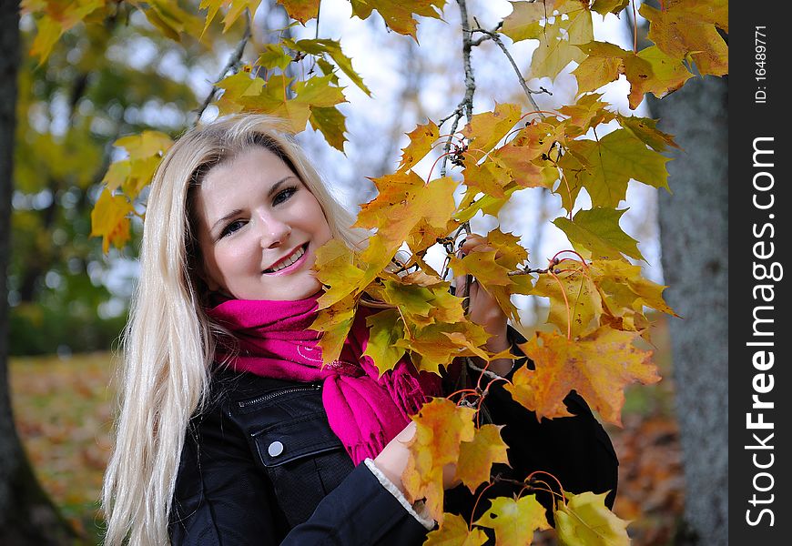 Beautiful autumn woman near yellow tree outdoors in forest