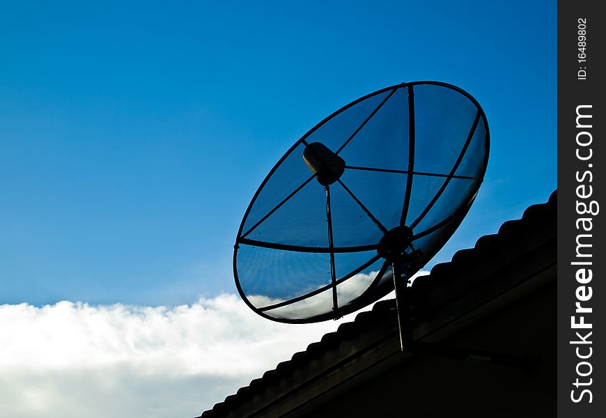 Small satellite on the roof with blue sky and white cloud