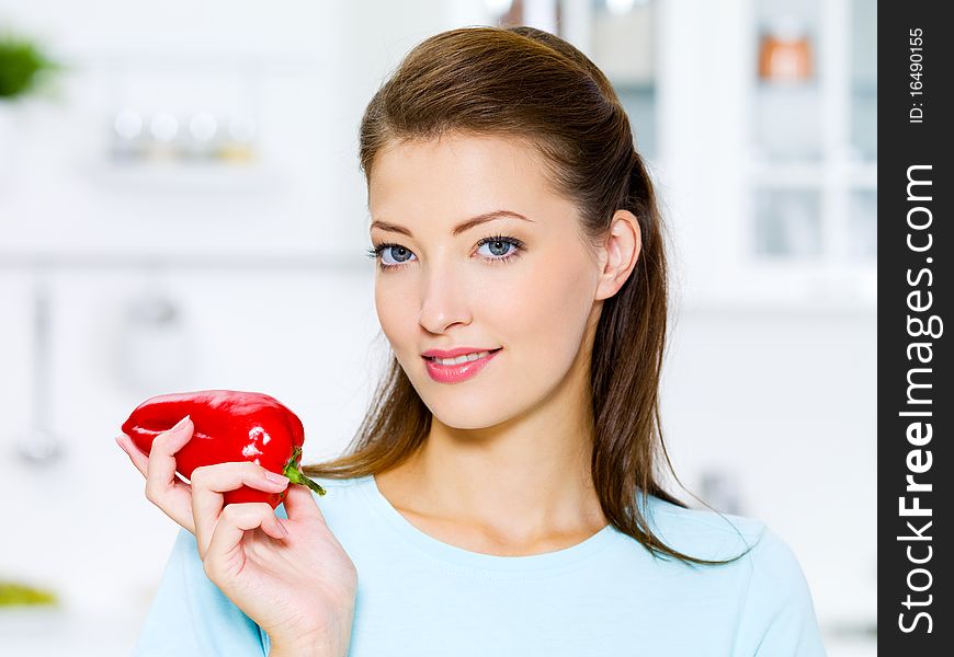 Beautiful woman with red pepper on kitchen. Beautiful woman with red pepper on kitchen