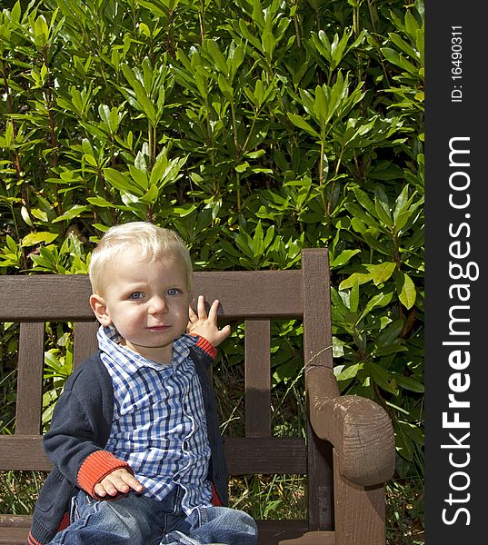 Toddler sat on bench looking anxious. Toddler sat on bench looking anxious