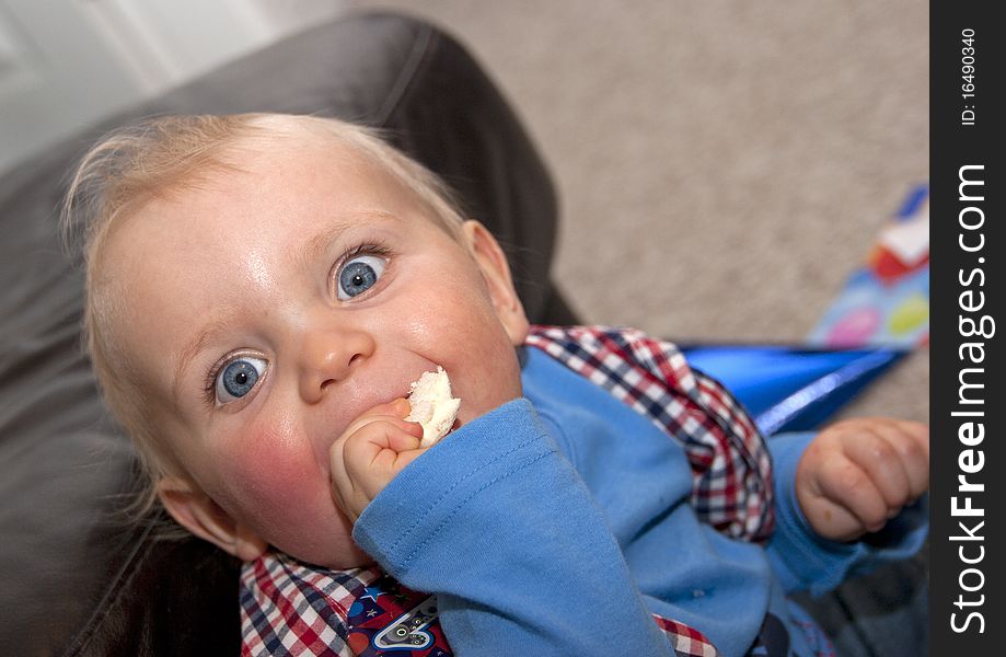 Happy baby boy on first birthday eating a sandwich. Happy baby boy on first birthday eating a sandwich