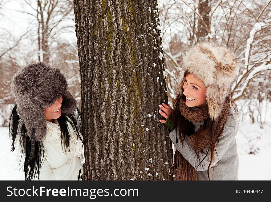 Snow playing female friends in winter park. Snow playing female friends in winter park