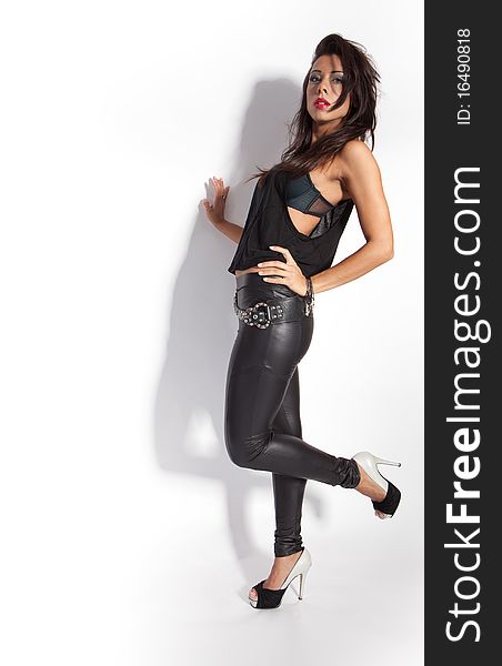 Beautiful female fashion model posing - isolated on white wearing shiny black leggings