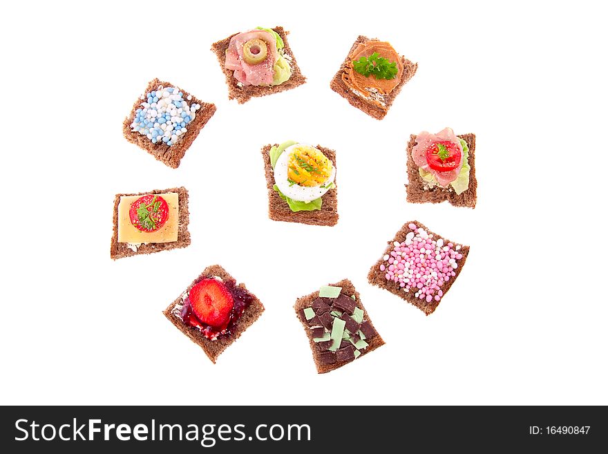 A circle of varied sweet and savory sandwiches   whole wheat bread isolated over white