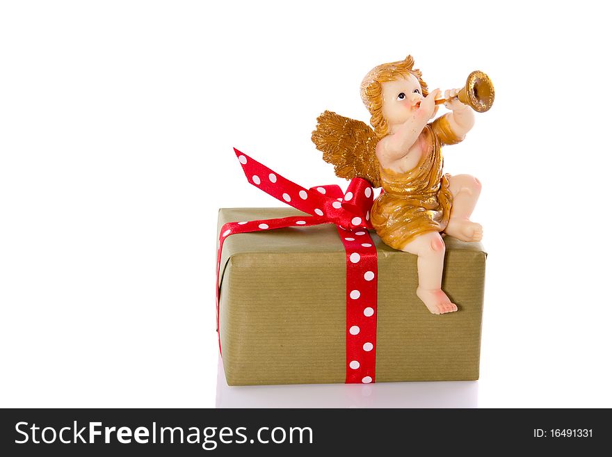 A musical angel on top of a present isolated on white background. A musical angel on top of a present isolated on white background