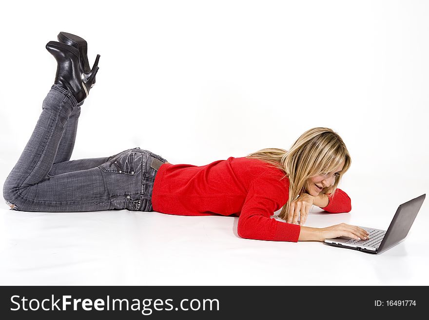 Happy working woman lying on the floor with her laptop