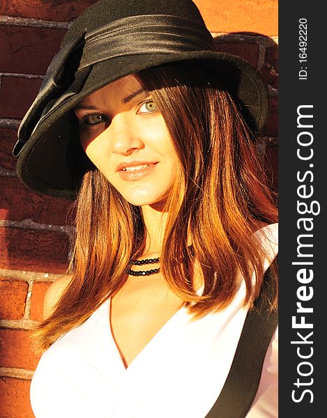 Portrait of a beautiful young woman in a black hat. Portrait of a beautiful young woman in a black hat