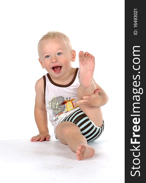 Beautiful smiling baby with dirty foot, isolated on white background