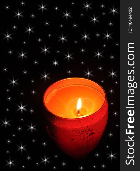 Red christmas candle over a black starry background. Red christmas candle over a black starry background