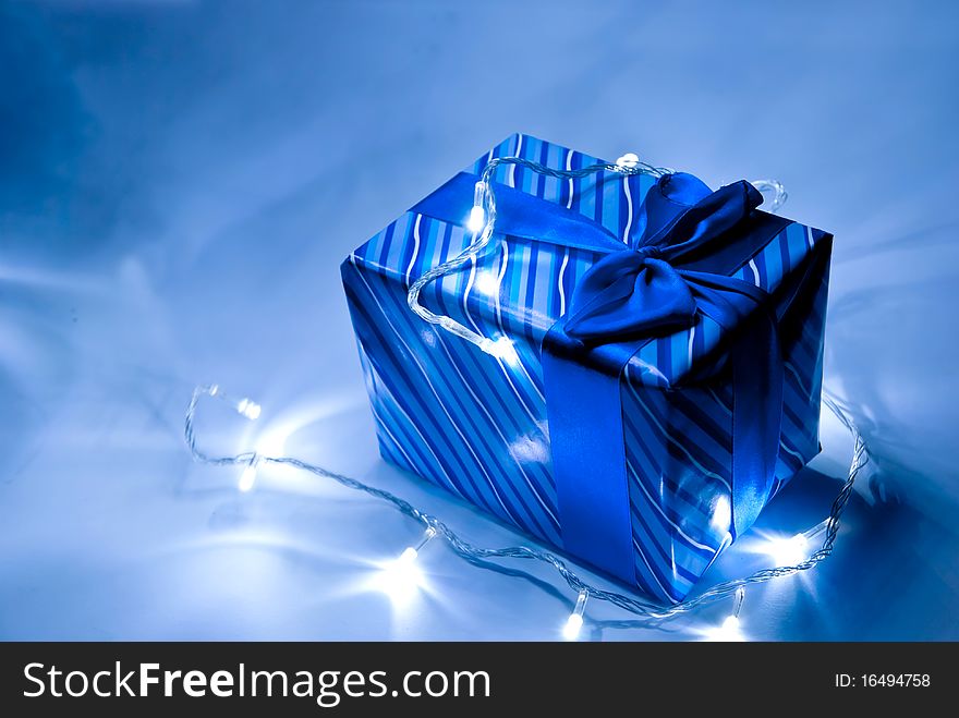 Blue gift box with ribbon and garland . Studio shot. Blue gift box with ribbon and garland . Studio shot