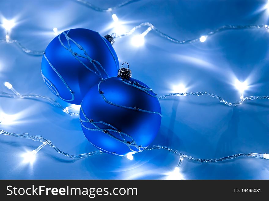 Two blue christmas balls with white garland. Two blue christmas balls with white garland