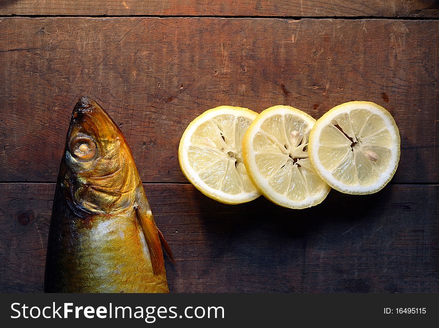 Freshness bloater near sliced lemon on wood background. Freshness bloater near sliced lemon on wood background