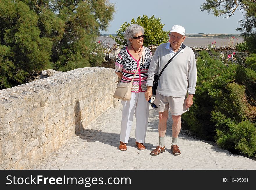 Happy senior couple walking along the coast of Brittany