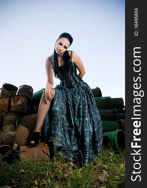 Woman wearing designer gothic dress in an industrial setting. Woman wearing designer gothic dress in an industrial setting