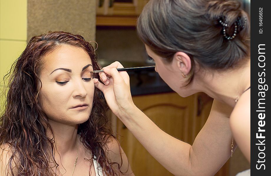 Make up artist applying eyeshadow on female model. Make up artist applying eyeshadow on female model