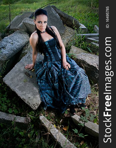 Woman wearing designer gothic dress in an industrial setting. Woman wearing designer gothic dress in an industrial setting