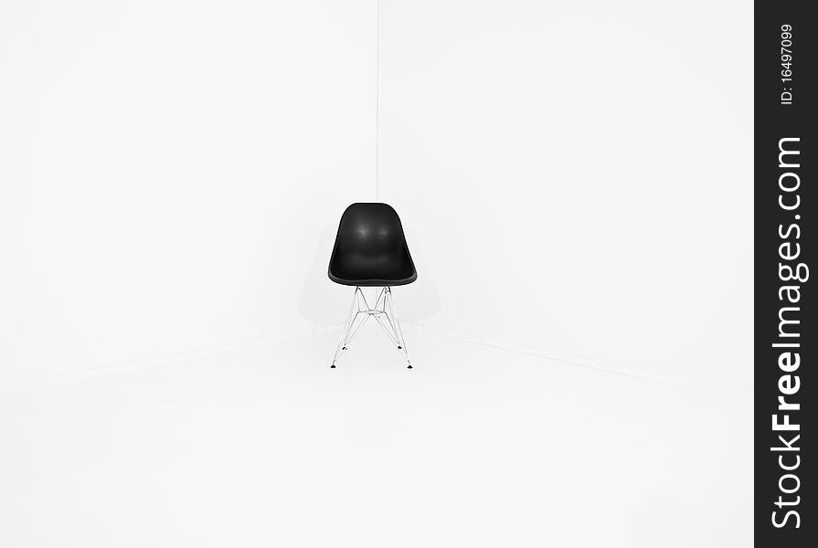 Lonely retro chair in a corner of a white room