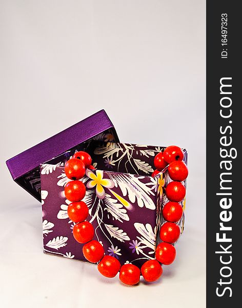 A purple gift box with red beads comming out
