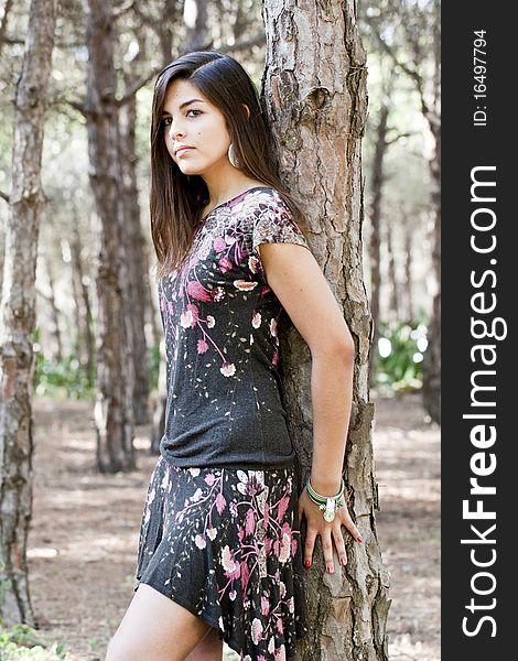 Beautiful girl with floral dress posing on a forest. Beautiful girl with floral dress posing on a forest.