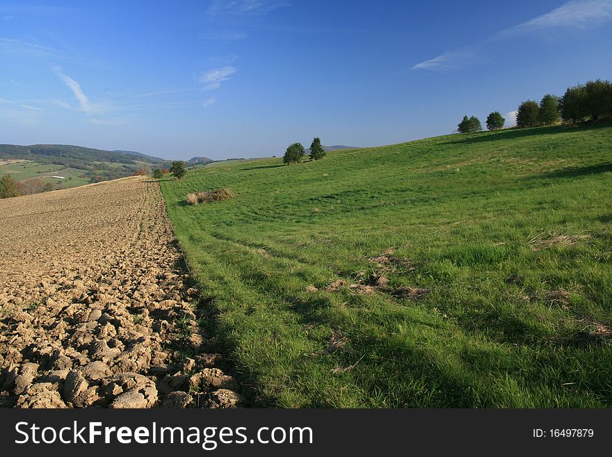 Green field in a mointainous area in summer time. Green field in a mointainous area in summer time