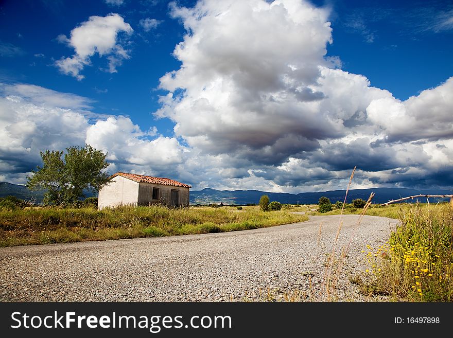 Idilic landscape with little house and road