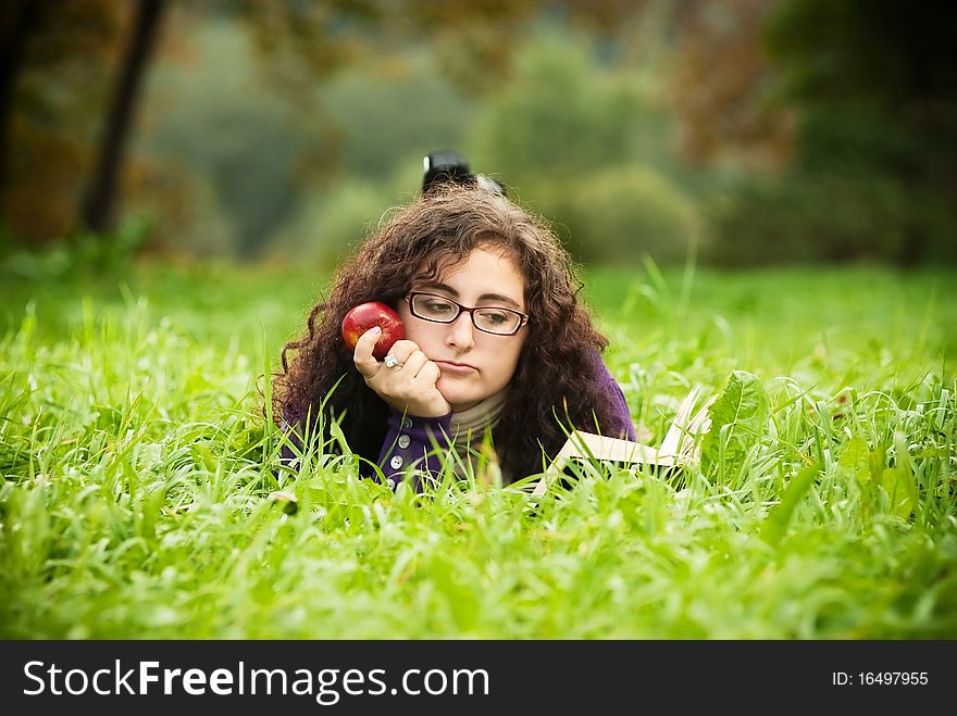Woman lays on a grass and reads the book. Woman lays on a grass and reads the book