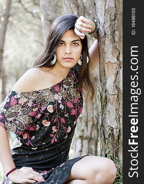 Beautiful girl with floral dress posing on a forest. Beautiful girl with floral dress posing on a forest.