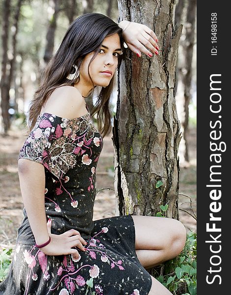 Beautiful girl with floral dress posing on a forest. Beautiful girl with floral dress posing on a forest.