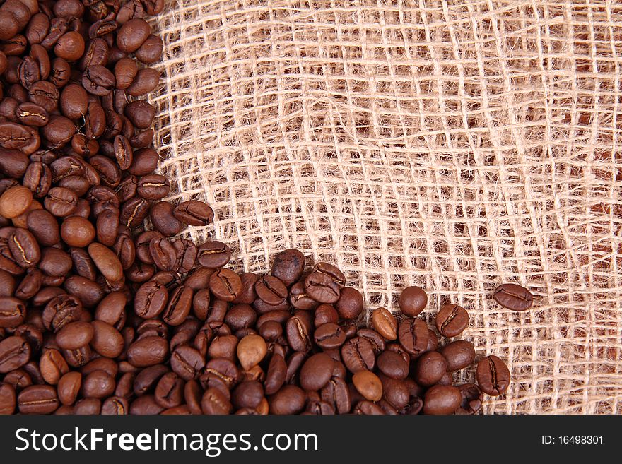 Coffee beans on burlap material background