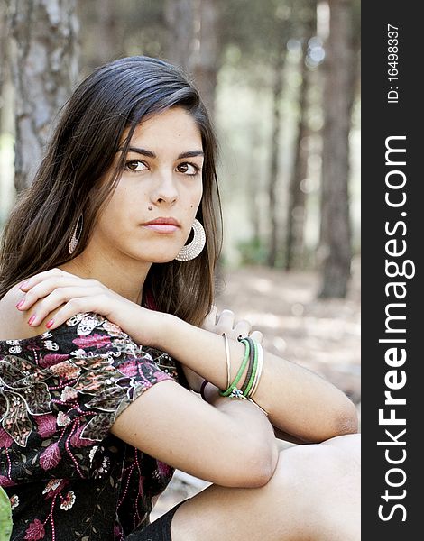 Beautiful girl with floral dress posing on a forest. Beautiful girl with floral dress posing on a forest.