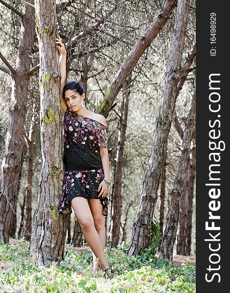 Beautiful girl with floral dress posing on a forest. Beautiful girl with floral dress posing on a forest.