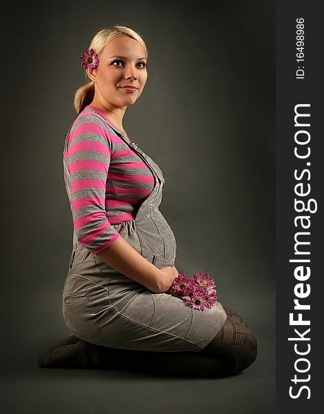 Pregnant young woman on dark background. Pregnant young woman on dark background