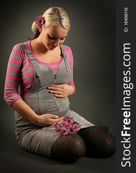 Pregnant young woman on dark background. Pregnant young woman on dark background