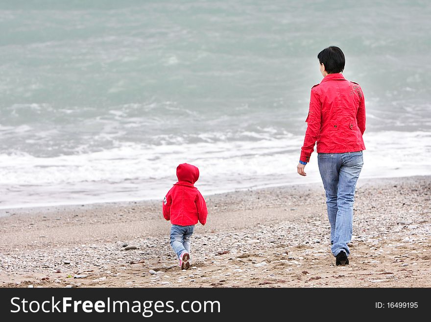 Mother and child walking on beach. Mother and child walking on beach