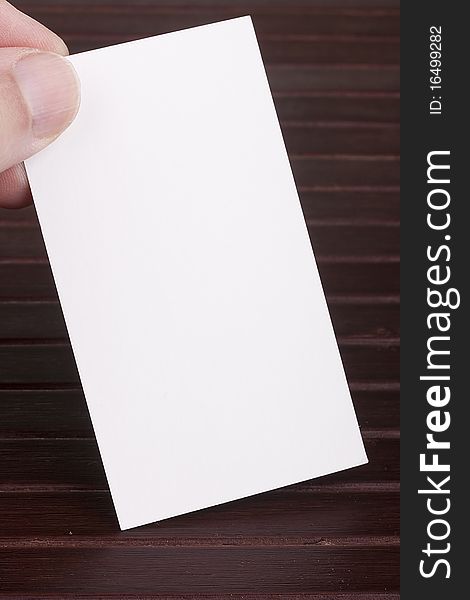 White sheet of construction paper in the form of a business card in a man's hand.