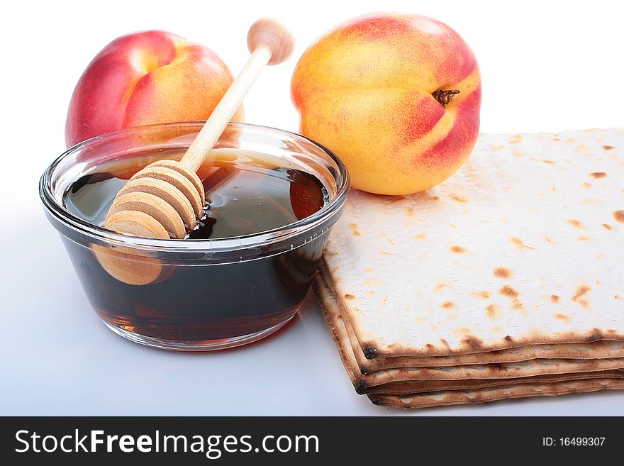 Honey in a glass vase with a special spoon, matzah and nectarine.